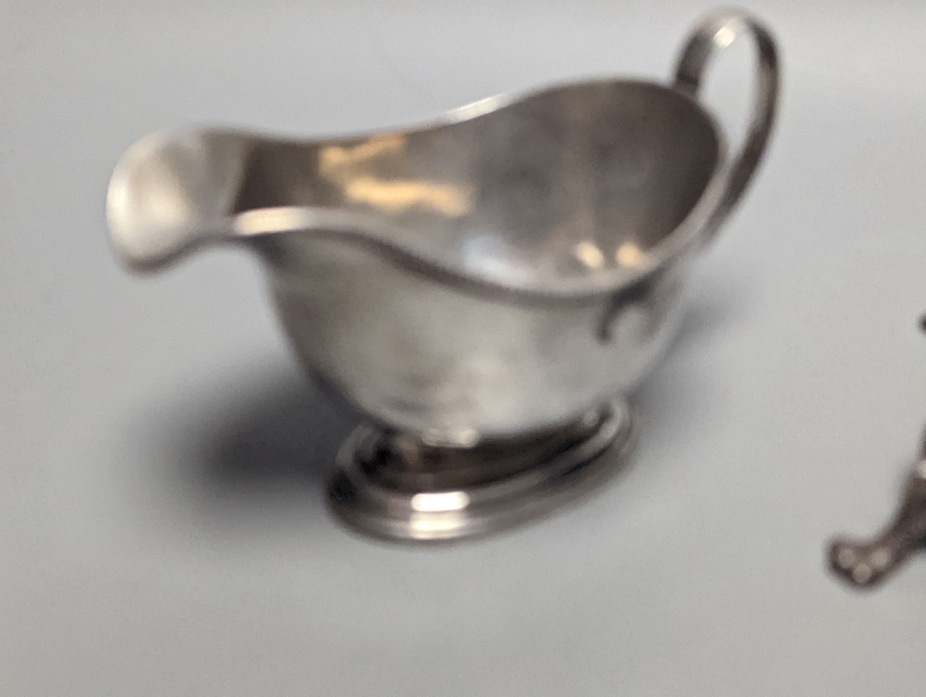 A George V silver sauceboat, an Edwardian silver pen tray and three other items including shell butter dish, 18oz.